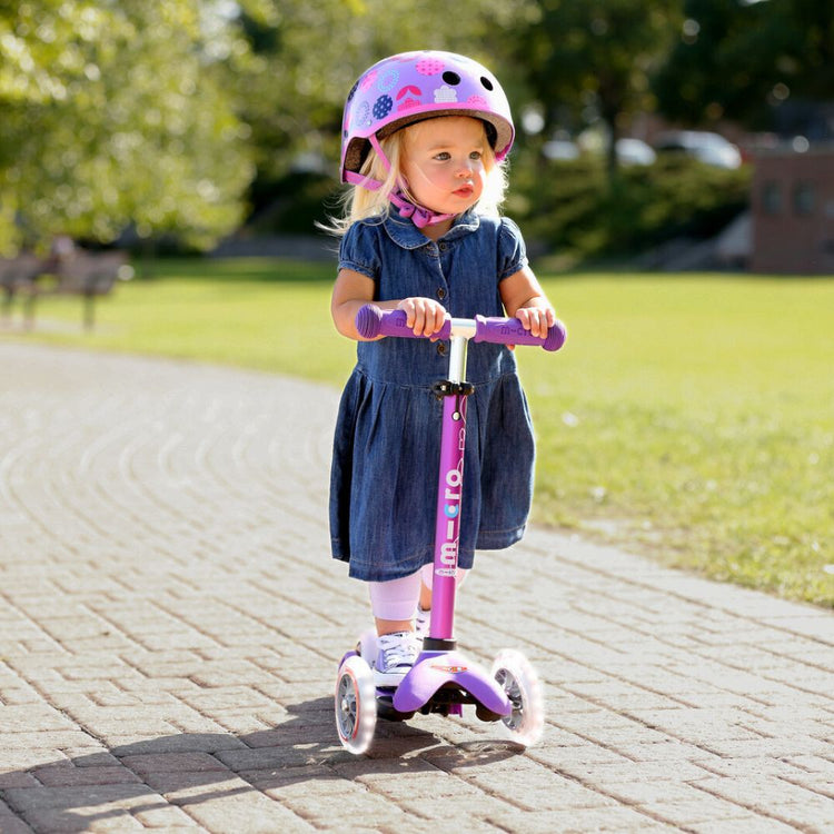 pige med lilla løbehjul og hjelm fra Micro Scooters