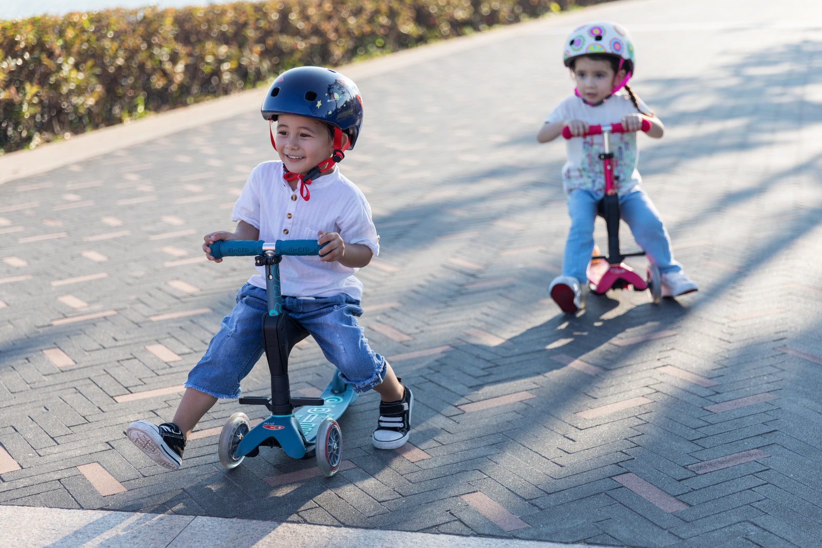 to børn med hjelme på der kører på løbehjul fra Micro Scooters